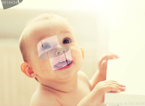 Image of happy little baby boy or girl at home looking up