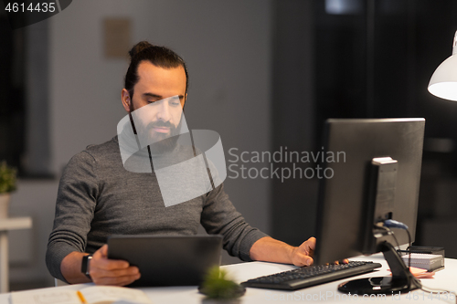 Image of creative man with computer working at night office