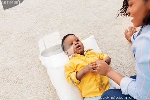 Image of happy african american mother with baby at home