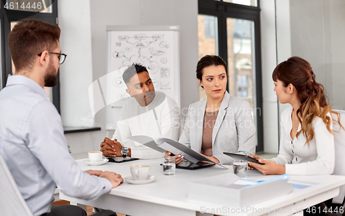 Image of recruiters having job interview with male employee