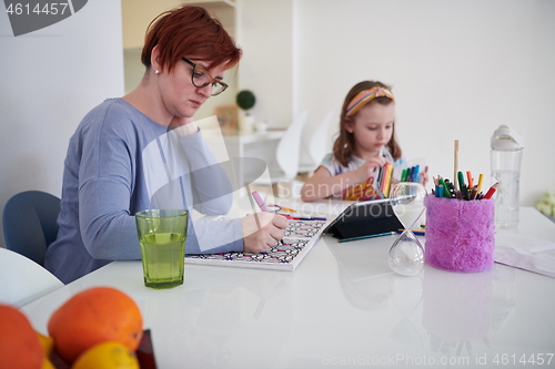 Image of Mother and little daughter  playing together  drawing creative a