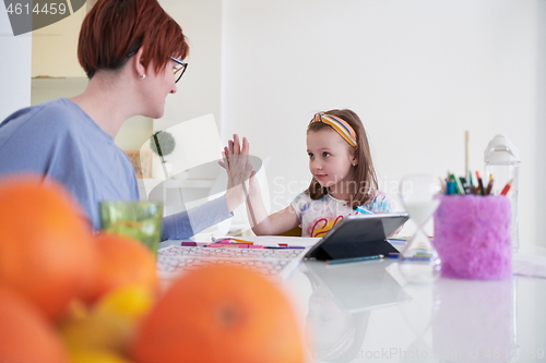 Image of Mother and little daughter  playing together  drawing creative a