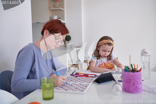 Image of Mother and little daughter  playing together  drawing creative a