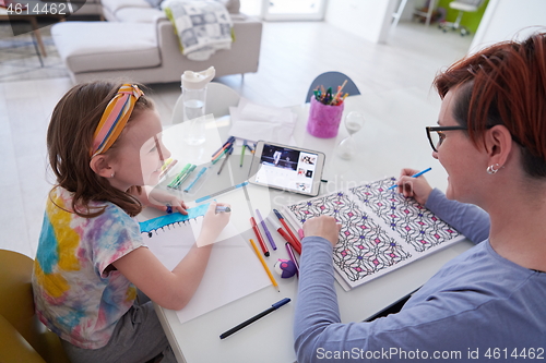 Image of Mother and little daughter  playing together  drawing creative a