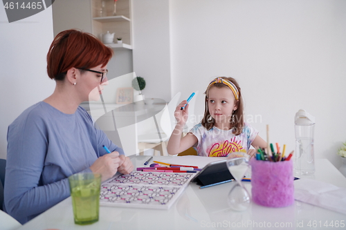 Image of Mother and little daughter  playing together  drawing creative a