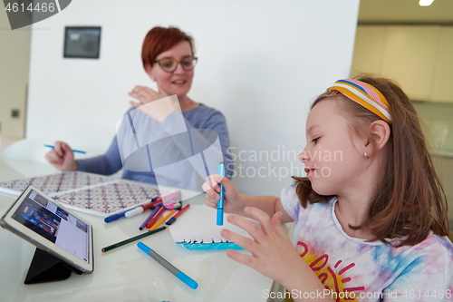 Image of Mother and little daughter  playing together  drawing creative a