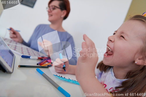 Image of Mother and little daughter  playing together  drawing creative a