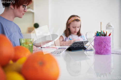 Image of Mother and little daughter  playing together  drawing creative a