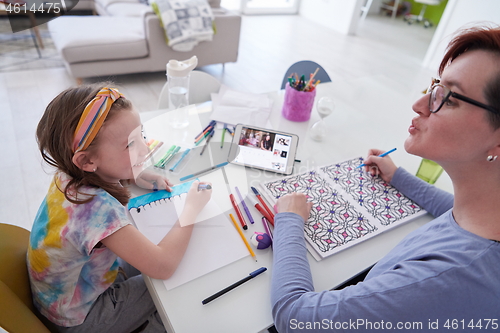 Image of Mother and little daughter  playing together  drawing creative a