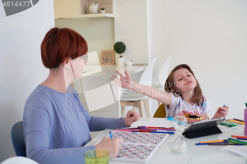 Image of Mother and little daughter  playing together  drawing creative a