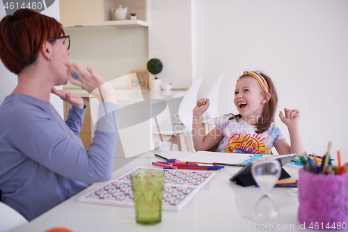 Image of Mother and little daughter  playing together  drawing creative a