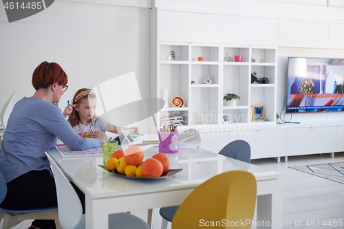 Image of Mother and little daughter  playing together  drawing creative a