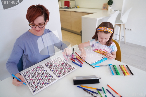 Image of Mother and little daughter  playing together  drawing creative a