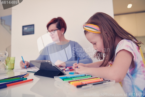 Image of Mother and little daughter  playing together  drawing creative a