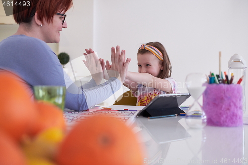 Image of Mother and little daughter  playing together  drawing creative a