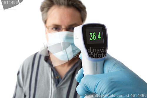 Image of A man is temperature checked for fever or high temperature 