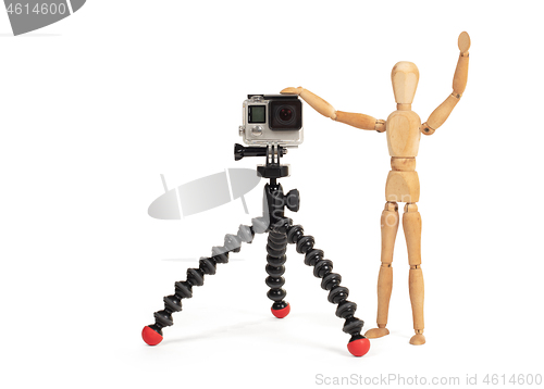 Image of Wooden dummy standing trying to make a video or photo