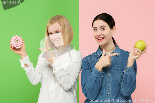 Image of Diet. Dieting concept. Healthy Food. Beautiful Young Women choosing between fruits and unhelathy cake