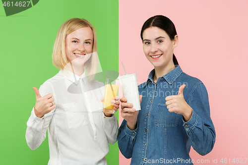 Image of Diet. Dieting concept. Healthy Food. Beautiful Young Women choosing between fruit orange juice and unhelathy carbonated sweet drink