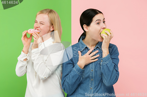 Image of Diet. Dieting concept. Healthy Food. Beautiful Young Women choosing between fruits and unhelathy cake