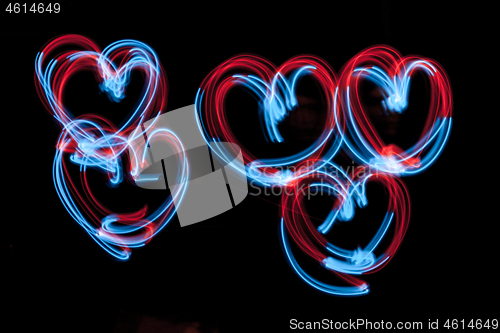 Image of The hearts - -shaped digital neon lights are on the dark background