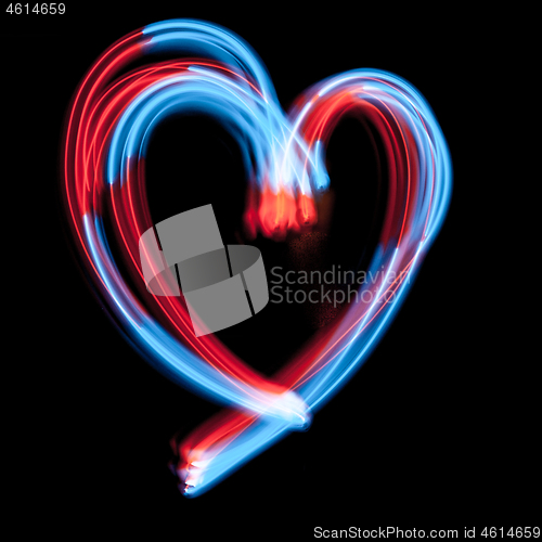 Image of The heart-shaped digital neon lights are on the dark background