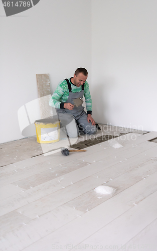 Image of worker installing the ceramic wood effect tiles on the floor