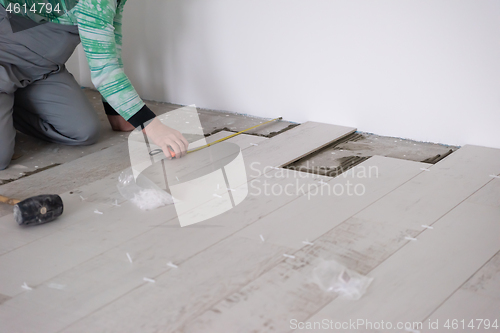 Image of worker installing the ceramic wood effect tiles on the floor