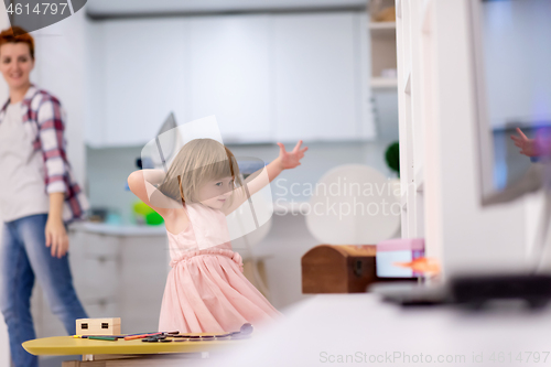 Image of mother and little daughter spending time together at home