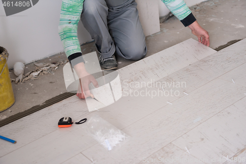 Image of worker installing the ceramic wood effect tiles on the floor