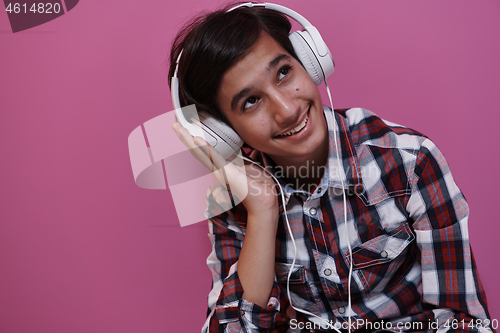 Image of Arab Teenage Boy Wearing Headphones And Listening To Music