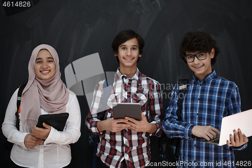 Image of Arab teenagers group working on laptop and tablet computer
