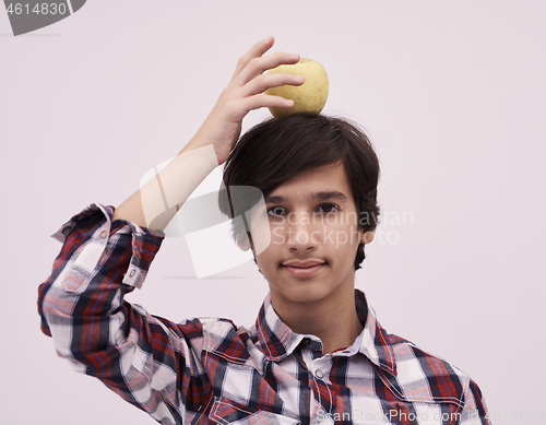 Image of portrait of a young  teen boy with an apple on his head