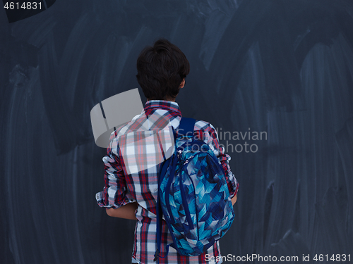 Image of arab teenager  with schoold backpack against black chalkboard