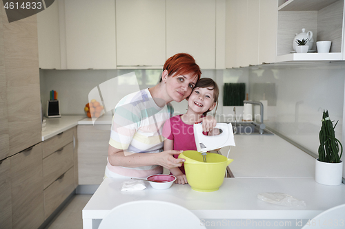 Image of Mother and daughter playing and preparing dough in the kitchen.