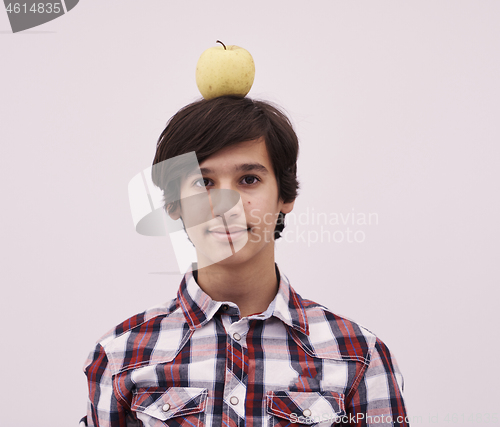 Image of portrait of a young  teen boy with an apple on his head