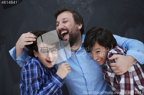 Image of happy father hugging sons