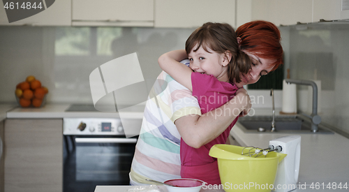 Image of Mother and daughter playing and preparing dough in the kitchen.