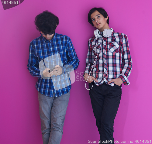 Image of Arab teenagers  against pink wall