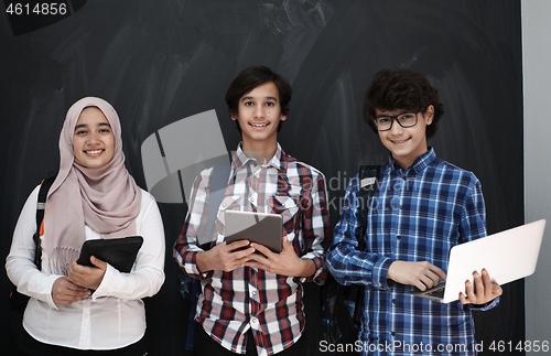 Image of Arab teenagers group working on laptop and tablet computer