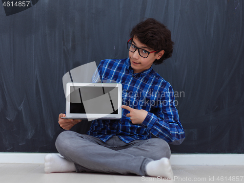 Image of Arab teenager using laptop to work on homework  at home