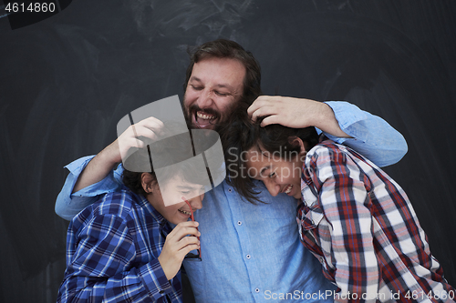 Image of happy father hugging sons