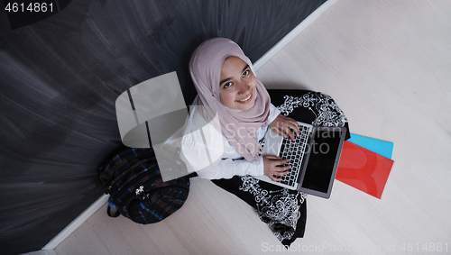 Image of arab female student working on laptop from home