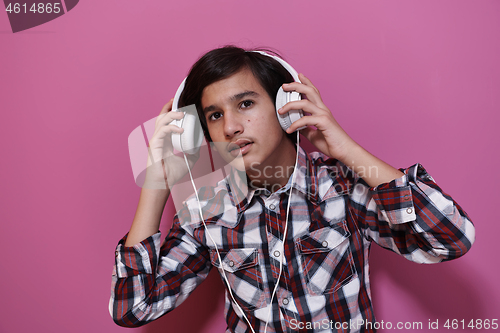 Image of Arab Teenage Boy Wearing Headphones And Listening To Music