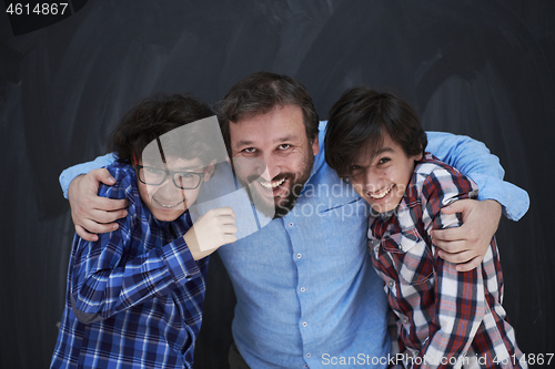 Image of happy father hugging sons