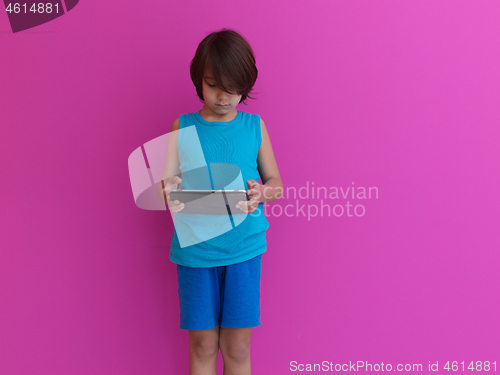 Image of Little Arabian boy using  on digital tablet pink background