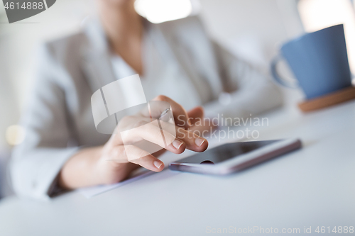 Image of hand of businesswoman using smartphone at office