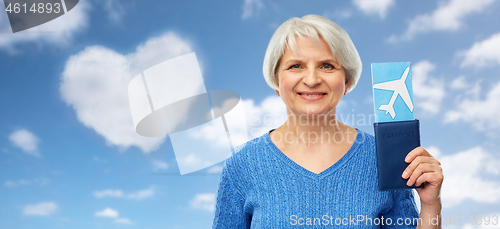 Image of senior woman with passport and airplane ticket