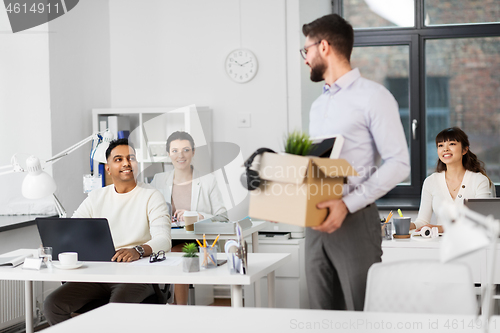 Image of happy male office worker with personal stuff