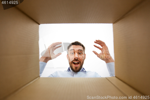 Image of happy suprised man looking into open parcel box